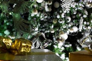 Glocke und Zubehör auf einem Weihnachtsbaumhintergrund foto