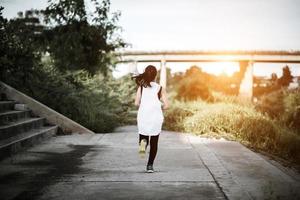 eine junge glückliche Läuferin, die draußen joggt foto