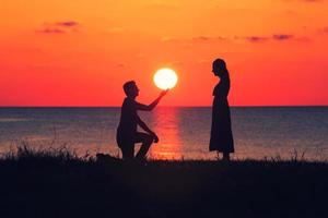 Silhouette eines Paares bei Sonnenuntergang foto