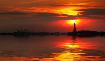 Freiheitsstatue Silhouette und die untergehende Sonne foto