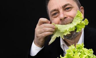 Mann, der Salat hält und isst foto