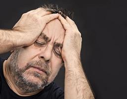Kopfschmerzen. Mann mit Gesicht von Hand geschlossen foto