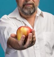 Mann, der roten Apfel in der Hand hält foto
