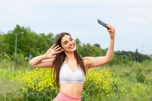 schöne junge frau, die im stadtrennen läuft und ein selfie macht, junge frau, die selfie macht, während sie fitnessübungen macht foto
