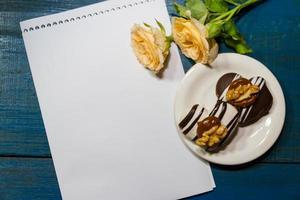 romantischer kaffeehintergrund mit süßen keksen und rosen mit grüßen foto