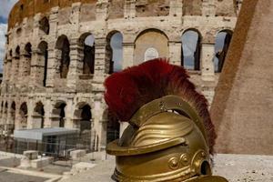 metallischer Gladiatorhelm auf Hintergrund des Kolosseums von Rom foto