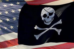 schwenkende Piratenflagge Jolly Roger auf USA Star and Stripes foto