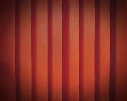 Nahaufnahme der Musterlinie aus orangefarbenem oder rotem Kunststoffvorhang mit Vignettenton für den Hintergrund. abstraktes, wand- oder tapetenkonzept foto