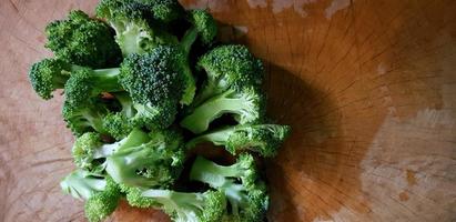 Frisch geschnittener Brokkoli auf Holzhintergrund mit rechtem Kopierraum zum Kochen von Speisen. stillleben gemüse, lebensstil für gesunde ernährung. ungekochtes Gemüse foto