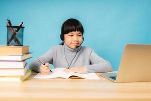 asiatische Mädchen sprechen und lernen online auf Laptop mit blauem Hintergrund