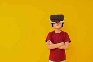 junges asiatisches mädchen mit virtual-reality-brille, kind wow und mit vr-präsentation auf gelbem hintergrund im studio foto