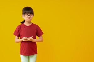 Porträt eines jungen asiatischen Schülers, der steht und Meditation macht, süßes thailändisches Mädchen in rotem Hemd mit Schultasche, das sich beruhigt und vor dem Lernen nach Wissen meditiert