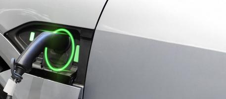 Ökostrom. weiße elektrofahrzeug-ladestation mit stromkabelversorgung steckstation zu hause, ev-ladestation, grüne energie, blaue energie, elektrische energie, technologie und ev-autokonzept foto