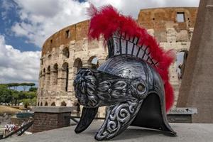 metallischer Gladiatorhelm auf Hintergrund des Kolosseums von Rom foto