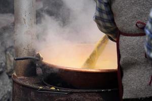 Rango, italien - 8. dezember 2017 - leute, die polenta traditionelles maisweizenmehl kochen foto