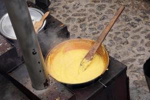 Rango, italien - 8. dezember 2017 - leute, die polenta traditionelles maisweizenmehl kochen foto