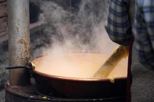 Rango, italien - 8. dezember 2017 - leute, die polenta traditionelles maisweizenmehl kochen foto