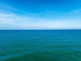 Luftaufnahme eines blauen Meeresoberflächenwasser-Texturhintergrundes, Luftaufnahme, fliegende Drohnenansicht, Wellen, Wasseroberflächenstruktur an sonnigen Tagen, tropischer Ozean, blauer Himmelshintergrund foto