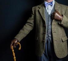 Porträt eines Mannes in Tweed-Anzug und Lederhandschuhen mit Regenschirm. Vintage-Stil des klassischen englischen Gentleman. foto