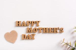 schönen Muttertag. Holzbuchstaben, Pappherzen und Eukalyptuszweige auf hellem Hintergrund. foto