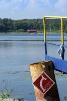 Holzbrücke am Seeufer, Wasseraufnahmeschild für Feuerwehrfahrzeuge foto