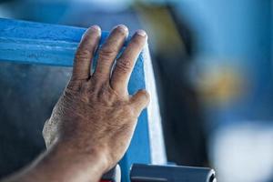 Hand des alten Mannes auf einem Fischerboot foto