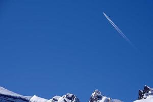 Flugzeugspuren verfolgen Chemtrails im tiefblauen Himmel foto