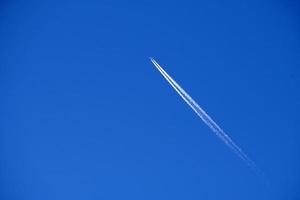 Flugzeugspuren verfolgen Chemtrails im tiefblauen Himmel foto