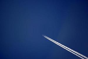 Flugzeugspuren verfolgen Chemtrails im tiefblauen Himmel foto