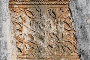 dekorelemente und steinmetzarbeiten mit spuren von zerstörung und vandalismus, die geisterstadt der griechischen stadt karmilissos bei fethiye in der türkei foto