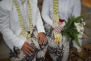 bräutigam und braut im weißen hochzeitskleid, das blumeneimer hält foto