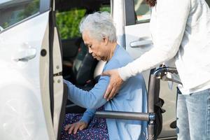 asiatische senior oder ältere alte damenpatientin, die im rollstuhl sitzt, bereiten sich auf ihr auto vor, gesundes starkes medizinisches konzept. foto