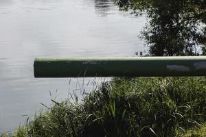 Abwasser aus dem Rohr in den Fluss ablassen foto