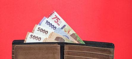 neue indonesische Banknoten in einer braunen Brieftasche foto