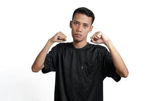 asiatischer mann, der schwarzes trainingst-shirt trägt und gestikuliert, um zu kämpfen. durch weißen Hintergrund isoliert foto