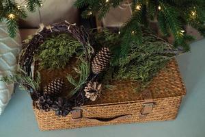 Weidenkoffer verziert mit Fichtenzweigen und einem Kegel. Weihnachtsdekoration foto
