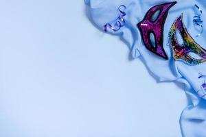 festliche gesichtsmasken für karnevals- oder maskeradefeiern auf farbigem hintergrund flach gelegt, draufsicht foto