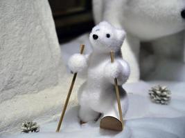 dekoratives Objekt, das einen niedlichen kleinen weißen Teddybären mit Stöcken darstellt foto