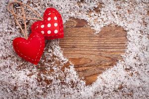 Liebesherzen auf einer Holzstruktur mit Schnee. valentinstag-kartenkonzept. Herz für Valentinstag Hintergrund. foto