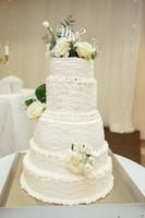luxus schöne weiße hochzeitstorte mit weißen rosen am hochzeitsempfang. Hochzeitstag foto