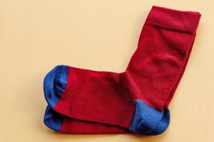 ein Paar Socken auf beigem Hintergrund. rote und blaue gestrickte Socken. foto