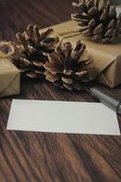 geschenkboxen in recyceltem papier und geschenkkarten, neujahrsgeschenkboxen auf einem holztisch, ein copyspace und eine braune weihnachtsgeschenkbox. foto