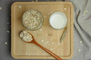 Pflanzenmilch aus Flocken in einem Glas auf einem Holztablett. vegetarisches diätetisches Essen foto