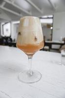 ein Glas Eiskaffee Latte mit Erdbeersirup und gekrönt mit Crackern oder Keksen foto