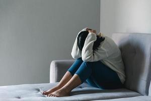 Konzept der traurigen Teenager-Depression. Umgekipptes Teenager-Mädchen, das drinnen am Fenster sitzt. angst junge frau verzweiflung und stress. Einsame und unglückliche Frauen sind soziale Opfer. Einsamkeit Jugend zu Hause. foto