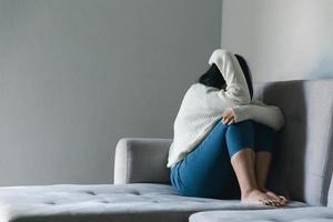 Konzept der traurigen Teenager-Depression. Umgekipptes Teenager-Mädchen, das drinnen am Fenster sitzt. angst junge frau verzweiflung und stress. Einsame und unglückliche Frauen sind soziale Opfer. Einsamkeit Jugend zu Hause. foto