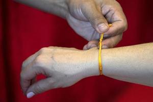 tibetischer Mönch beim Anlegen des Armbands an der buddhistischen Hand foto