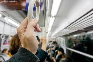 Nahaufnahme Hand der menschlichen Haltegriffschlaufe in einem U-Bahn-Morgen und verschwommenem Hintergrund. foto