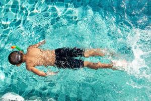 Junge hat Spaß beim Spielen im Pool foto