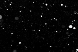 Bokeh weißer Schnee auf einem schwarzen Nachthintergrund foto